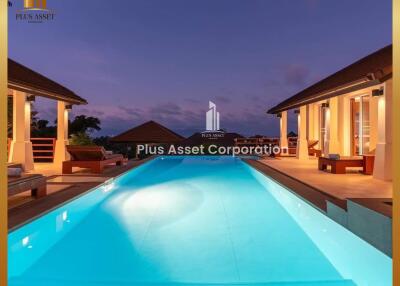 Luxurious outdoor pool area of a residential estate at twilight with illuminated pool and villa