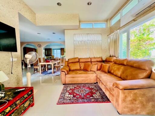 Spacious and brightly lit living room with large sectional sofa and modern amenities