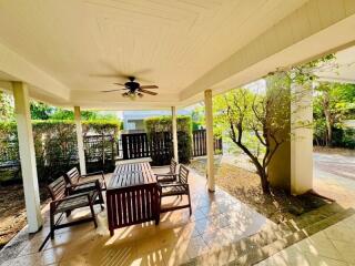 Cozy covered patio with wooden furniture and garden view