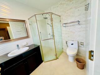 Modern bathroom with glass shower enclosure and marble walls