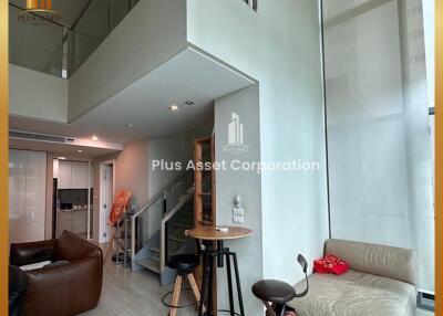 Modern living room with loft stairs and high ceiling