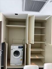 Compact laundry room with built-in storage and modern washing machine