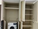 Compact laundry room with built-in storage and modern washing machine