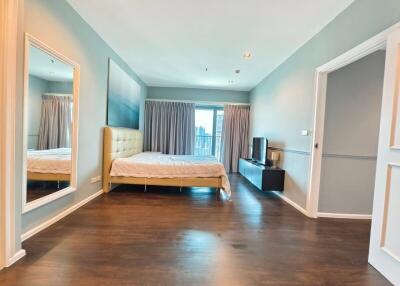 Spacious bedroom with large window and hardwood floors