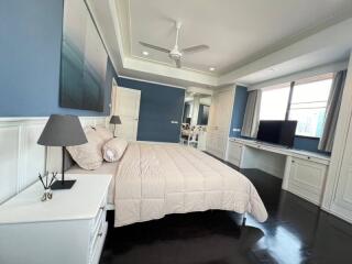 Elegant master bedroom with desk area and modern design