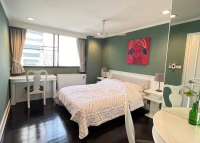 Spacious bedroom with large bed, wooden floors and modern decor