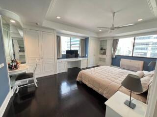 Spacious bedroom with hardwood flooring, custom cabinetry, and modern amenities