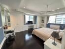 Spacious bedroom with hardwood flooring, custom cabinetry, and modern amenities