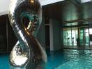 Elegant poolside with reflective sculpture in a modern residential building