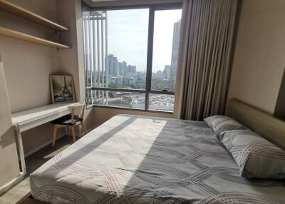 Spacious modern bedroom with large window and city view