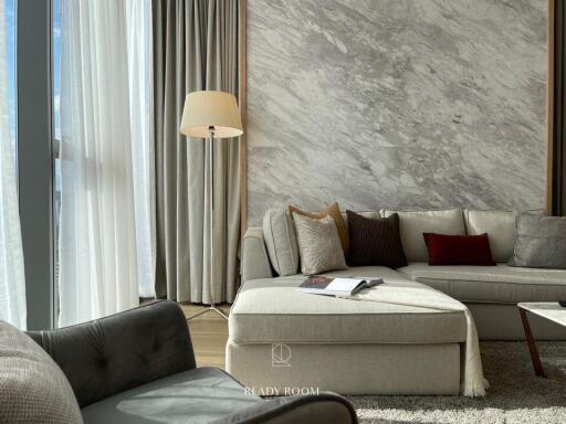 Modern living room with a luxurious marble wall and a cozy seating arrangement