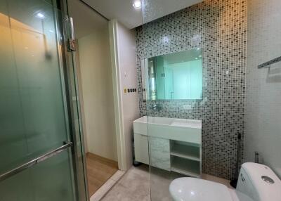 Modern bathroom with glass shower enclosure and stylish tiled walls