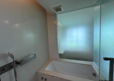 Modern bathroom interior with frosted glass shower and built-in bathtub