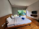 Spacious bedroom with large window overlooking garden