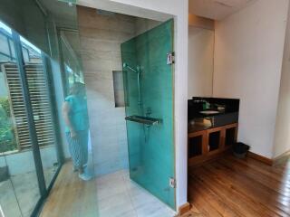 Modern bathroom with glass shower enclosure and wooden vanity