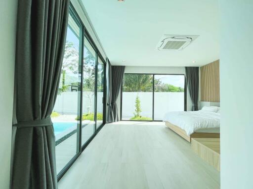 Modern bedroom with large windows and garden view