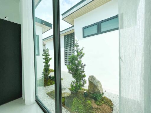 Modern room view with floor-to-ceiling windows overlooking a serene garden