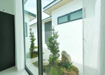 Modern room view with floor-to-ceiling windows overlooking a serene garden