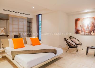 Spacious modern bedroom with large bed, vibrant accents, and elegant artwork in a luxury home