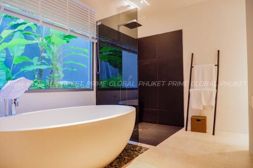 Luxurious modern bathroom with freestanding bathtub and indoor garden view