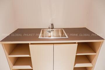 Modern kitchen sink with open beige storage cabinets