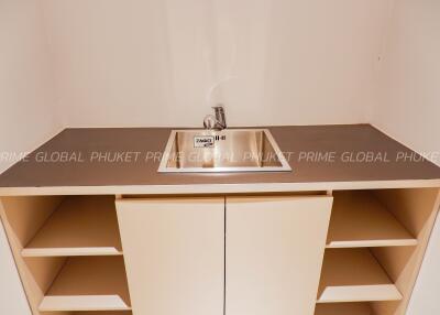 Modern kitchen sink with open beige storage cabinets