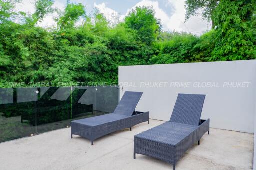 Outdoor patio area with comfortable sun loungers and lush greenery