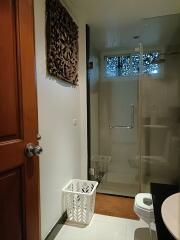 Modern bathroom with glass shower enclosure and elegant wooden details