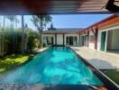 Luxurious outdoor pool with lush garden and modern house in the background