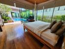 Spacious bedroom with pool view, large windows and wooden flooring