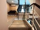 Elegant wooden staircase leading to an upper floor with a view into a cozy bedroom