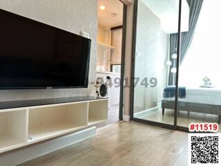Modern living room with entertainment unit and sliding glass door leading to adjacent room