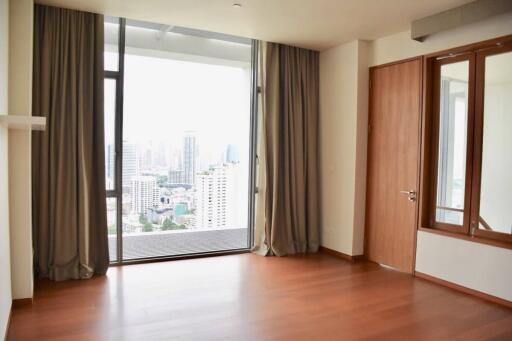 Spacious bedroom with large windows and cityscape view