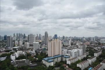 Panoramic cityscape view featuring a dense cluster of buildings under a cloudy sky