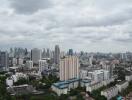 Panoramic cityscape view featuring a dense cluster of buildings under a cloudy sky