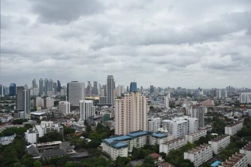 Panoramic cityscape view featuring a dense cluster of buildings under a cloudy sky