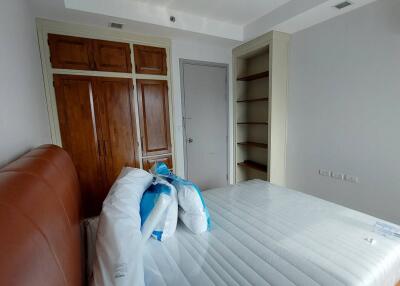Unfurnished bedroom with wooden door and built-in shelving