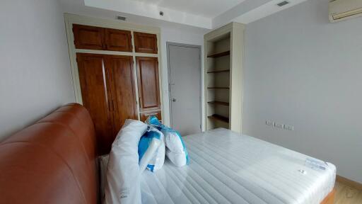 Unfurnished bedroom with wooden door and built-in shelving