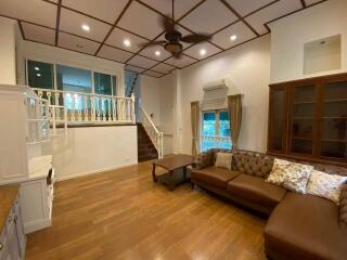 Spacious living room with wooden floor and elegant furnishings including a staircase