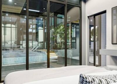 Modern bedroom with large glass windows overlooking the pool