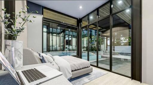 Modern bedroom with large glass windows overlooking the pool
