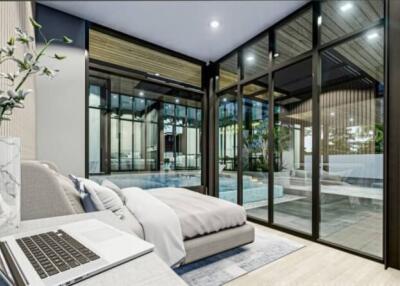 Modern bedroom with large glass windows overlooking the pool