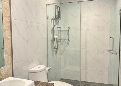 Modern bathroom with marble tiling and glass shower enclosure