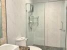 Modern bathroom with marble tiling and glass shower enclosure