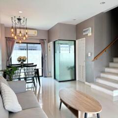Spacious and modern living room with staircase and ample natural lighting