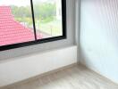 Bright bedroom with large window and view of red roof