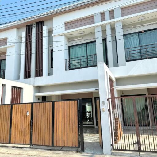 Modern two-story residential building with wooden gate entrance