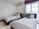 Spacious bedroom with two single beds and bright window