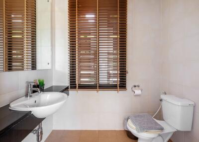 Modern bathroom with wooden blinds and white fixtures