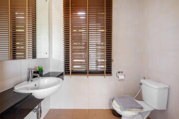 Modern bathroom with wooden blinds and white fixtures